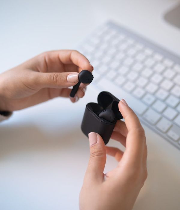 Premium wireless earbuds with charging case on modern desk setup