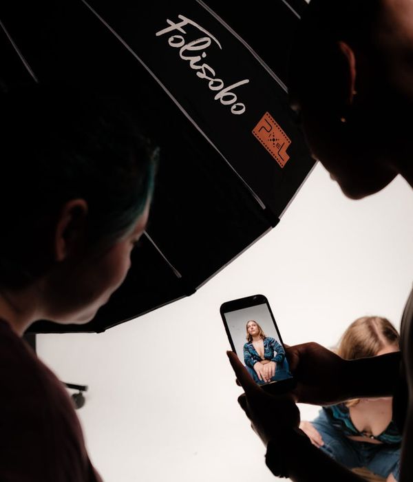 Professional tech reviewer testing latest smartphone with camera equipment and lighting setup